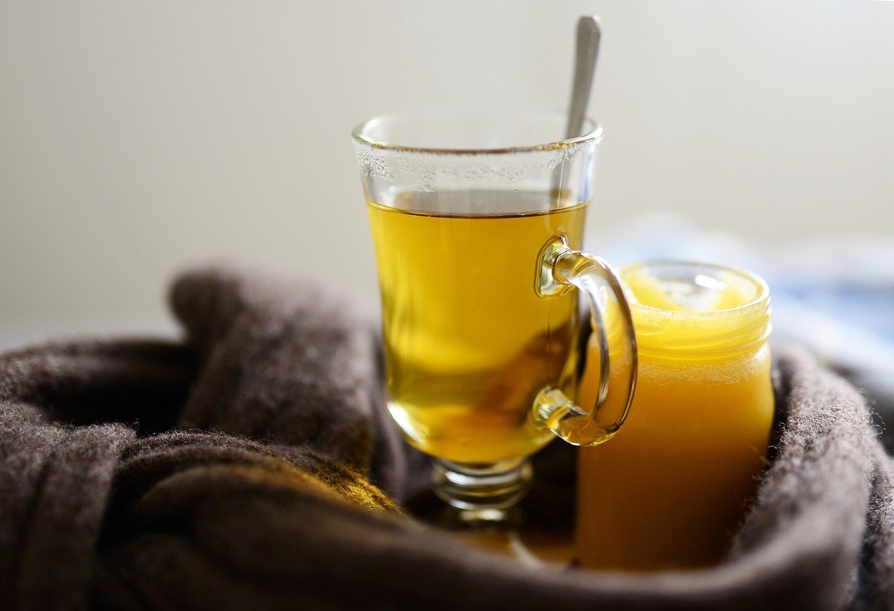 A glass of herbal tea with honey, a common home remedy for cold and flu